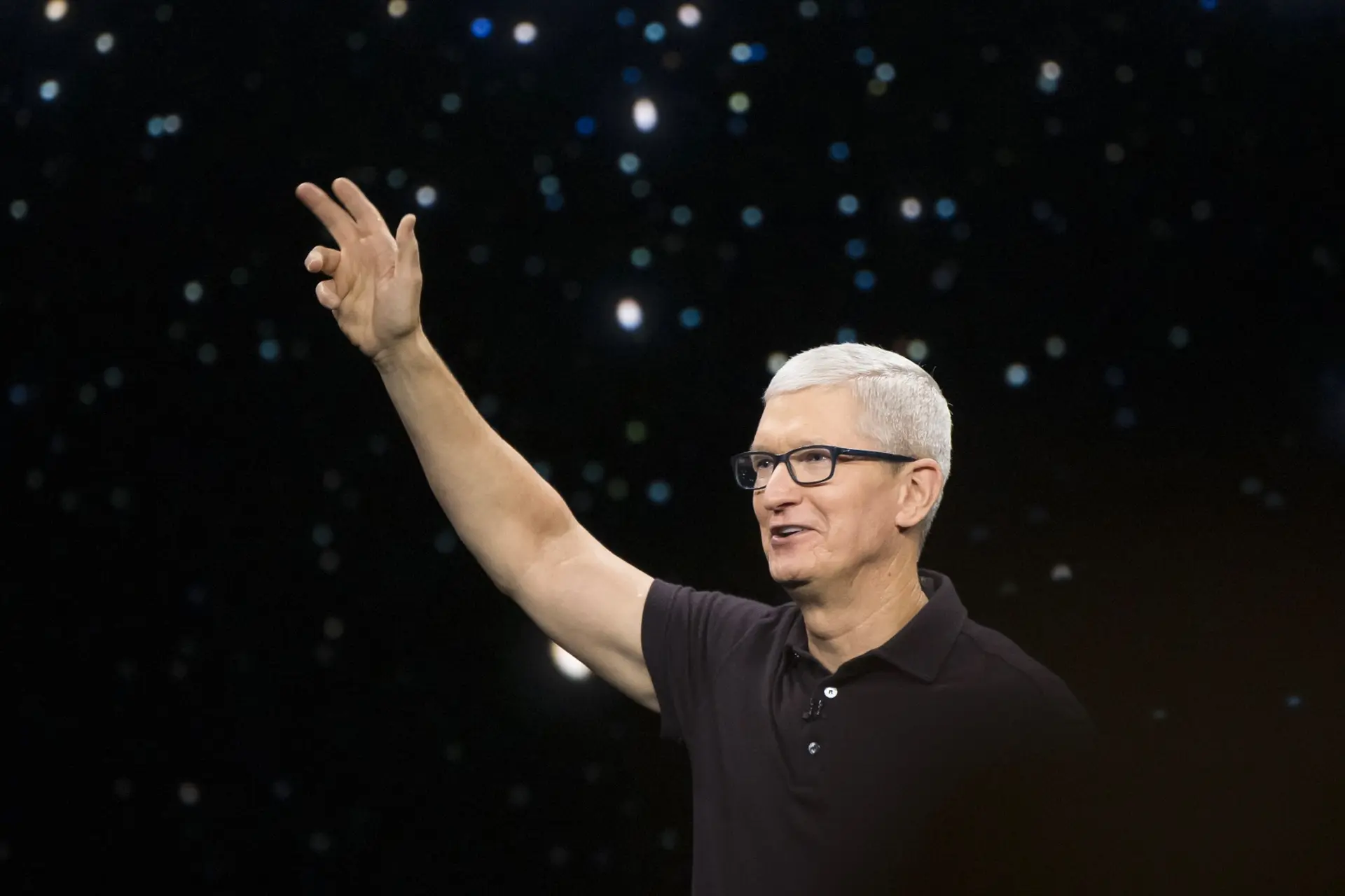 Tim Cook, CEO of Apple, happy with his hands up