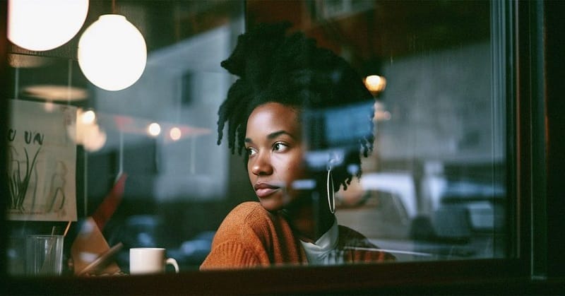 A black woman behind the window of a cafÃ©